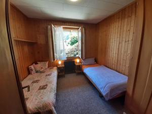 a small room with two beds and a window at Cozy Chalet by Interlaken. Parking in Ringgenberg