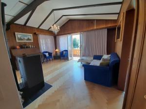 a living room with a blue couch and a tv at Cozy Chalet by Interlaken. Parking in Ringgenberg