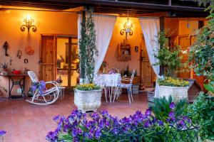un patio con tavolo, sedie e fiori di B&B Glicine ad Ancona