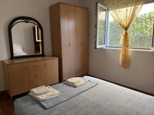 a bedroom with a bed and a mirror and a window at Apartman Any Bar in Bar