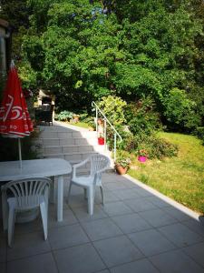 eine Terrasse mit einem Tisch, 2 Stühlen und einem Sonnenschirm in der Unterkunft Chez Eliane in Villeneuve-la-Comptal