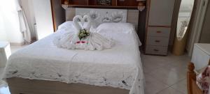 Una cama blanca con dos conejos vestidos de blanco en La Necussella, en Anacapri