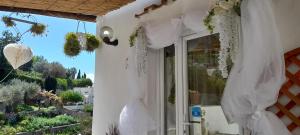 ein weißes Haus mit einem Fenster mit weißen Vorhängen in der Unterkunft La Necussella in Anacapri