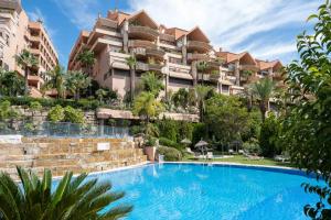 un complejo con piscina frente a un edificio en Nueva Andalucia Magna Marbella Golf, en Marbella