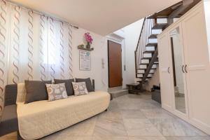 a living room with a couch and a staircase at Modern House 5 Star - Parcheggio & Wi-Fi Gratis in Ferrara