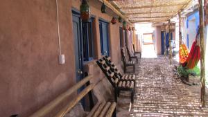 a row of benches next to a building at Hostal Mamatierra in San Pedro de Atacama +13 photos