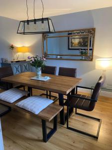 uma sala de jantar com uma mesa de madeira e cadeiras em Mounvaud Lodge em Stradbally