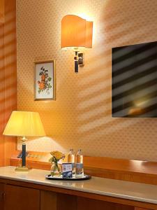 Cette chambre dispose d'une table avec une lampe et d'une télévision. dans l'établissement Hotel Motel Top, à Cusago