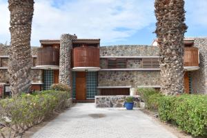 an exterior view of a house with two palm trees at ELSA TAURO TOPAZ in Mogán