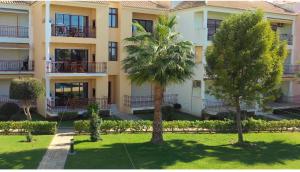 un bâtiment avec un palmier en face dans l'établissement Beach Apartment Villa Columbus, à Vilamoura