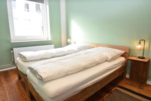 een bed met witte kussens in een kamer bij fewo1846 - Stadtbude - komfortable 2-Zimmer-Wohnung mitten im Stadtzentrum in Flensburg