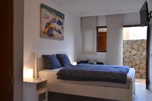 a bedroom with a bed with blue sheets and a window at ELSA TAURO TOPAZ in Mogán