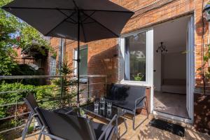 a patio with a table and two chairs and an umbrella at SopotSpanie in Sopot