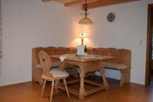 a wooden table with two chairs and a lamp on it at Holstein-Höfle, Rindalphorn in Argenbühl