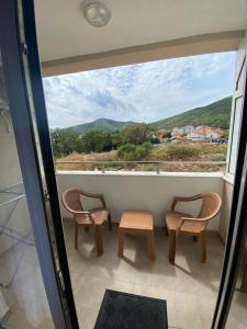 a balcony with two chairs and a large window at Apartment Marko in Budva