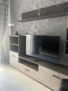 ein großes Entertainment-Center mit einem großen Flachbild-TV in der Unterkunft Appartamento Mire&Geo in Voghera