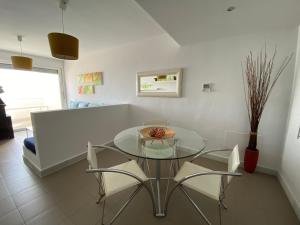 a dining room with a glass table and chairs at Calagrande in Almería +4 photos