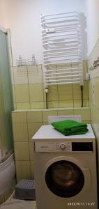 a washing machine with a green towel on top of it at Słoneczny Zakątek in Jaworki