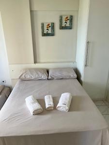 a bed with two white towels on top of it at Puerto de Villas in Recife +8 photos