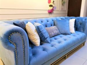 un sofá azul con muchas almohadas en 皇家海景ROYAL Luxury Seaview Room, 3 minute to Gurney en Tanjong Tokong