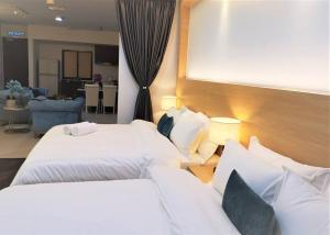 um quarto de hotel com duas camas e uma sala de estar em 皇家海景ROYAL Luxury Seaview Room, 3 minute to Gurney em Tanjong Tokong