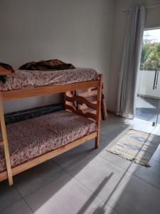 Habitación con 2 literas y ventana en Xodó da Praia - amplo apartamento 3 qts 260 m da praia, en Santa Cruz