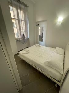 マントンにあるCasa mia Mentonの窓のある部屋にある白いベッド