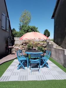a blue table with chairs and an umbrella at Gite Les Marmottes in Trémouille