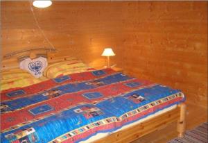 a bed in a room with a wooden wall at Ferienhaus Schlagintweit in Drachselsried