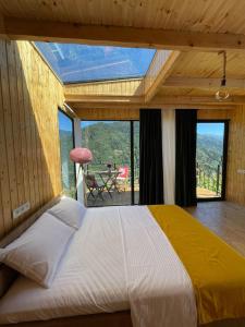 duże łóżko w pokoju z dużym oknem w obiekcie House in mountains, near Batumi- Lemanor Lodge w mieście Kʼveda Chʼkhutunetʼi