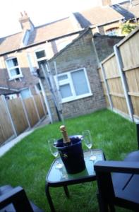 a table with a bottle of wine and two glasses at 2 Bedroom Luton Townhouse in Luton