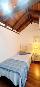 una camera da letto con un letto con una coperta blu sopra di Casa Los Agapantos a Breña Alta