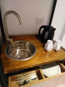 a kitchen counter with a sink and a kettle at Casa Be Suites in Rosario