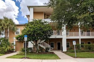 ein großes Apartmenthaus mit einem Balkon und Bäumen in der Unterkunft Hidden Oasis near Orlando, Disney, etc. in Kissimmee