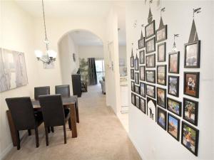 une salle à manger avec une table et un mur de photos dans l'établissement Hidden Oasis near Orlando, Disney, etc., à Kissimmee