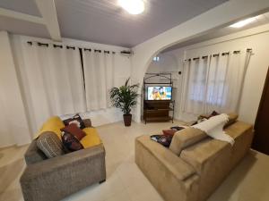 sala de estar con 2 sofás y TV en Casa praia da cachoeira, en Florianópolis