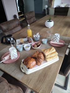 a table with a tray of pastries and orange juice at Locabreizh 22 in Plourivo