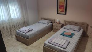 two beds in a small bedroom with at Airport's Close, Cozy Flat for 6 Persons in Markopoulo