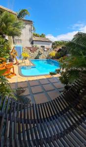 a swimming pool with a fence in front of it at Pousada Vila Morena in Itaúnas