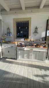 a large kitchen with white cabinets and a wooden floor at Corte Caselle in Sommacampagna
