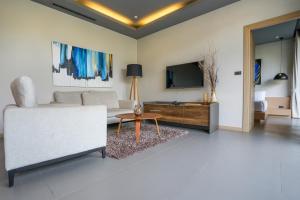 sala de estar con sofá blanco y TV en Sunpao Pool Villa by HCR en Layan Beach