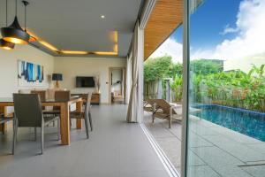 a dining room with a table and a swimming pool at Sunpao Pool Villa by HCR in Layan Beach