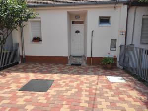 a white house with a white door and a patio at BlankApartman in Mohács