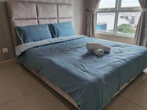 1 cama grande con edredón azul y ventana en SUMMERSET 8PAX 3BR LUXURY SEAVIEW SUITE ROOM en George Town