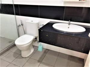 La salle de bains est pourvue de toilettes et d'un lavabo. dans l'établissement SUMMERSET 8PAX 3BR LUXURY SEAVIEW SUITE ROOM, à George Town