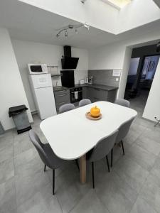 una cucina con un tavolo bianco e sedie in una stanza di L'amiénoise proche zenith stade cathédrale ad Amiens