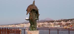 a statue of a bird sitting on top of a pole at Sunny Beach Apartments in Rethymno Town