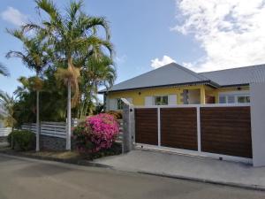 a house with a wooden fence and palm trees at Le Langka in Saint-Louis