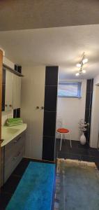 a room with a kitchen with a table and a chair at Schöne Ferienwohnung mit Terrasse und Garten in Überherrn +26 photos