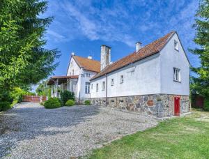 an exterior view of a white house with a stone driveway at Grabnicka Arkadia in Stare Juchy